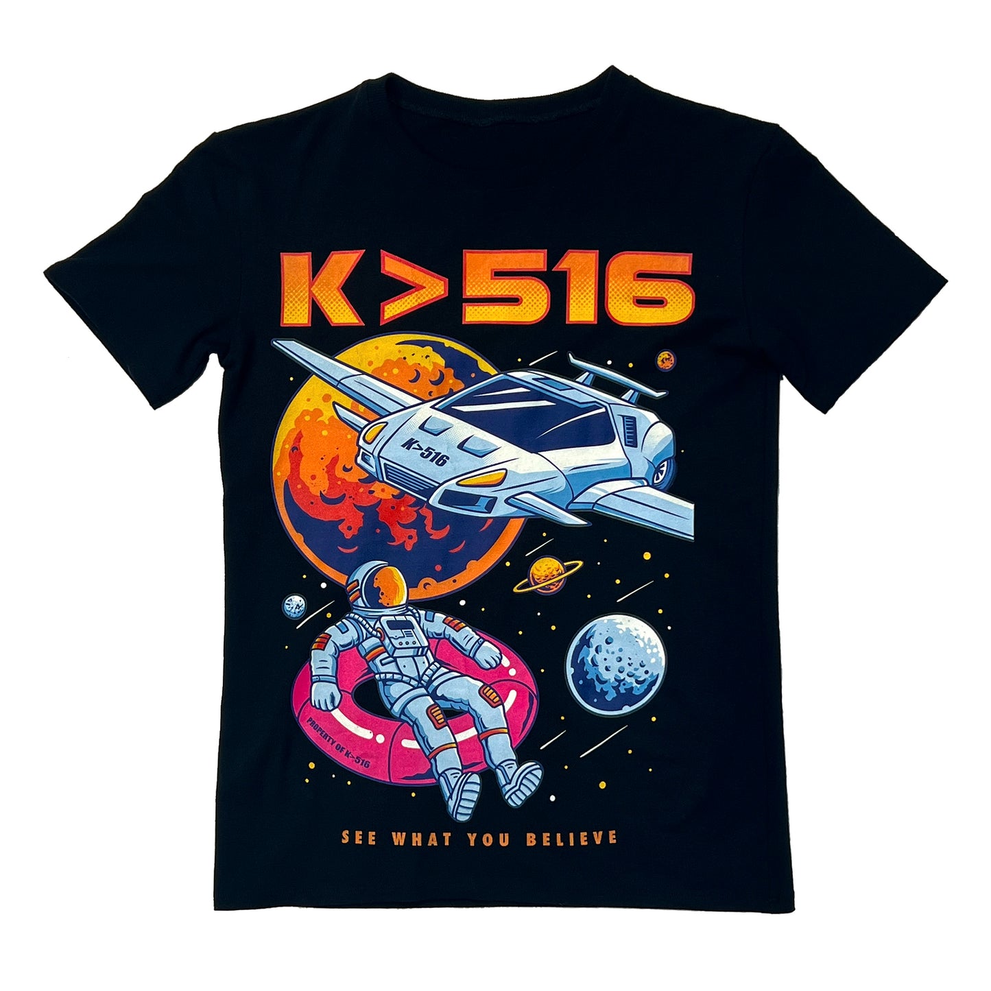 A black, soft, premium t shirt with a large multicolored graphic. Which shows an astronaut in space sitting on a pink floaty while a white car flies above them with planets and multiple stars in the background. Along with the phrase "See What You Believe" at the bottom and the brand name K>516 at the top.